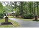 Long paved driveway leading to a brick home surrounded by lush trees and landscaping at 14236 Wyndfield Cir, Raleigh, NC 27615