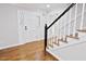 Bright entryway with hardwood floors, white trim and a staircase with a black handrail at 14236 Wyndfield Cir, Raleigh, NC 27615
