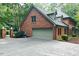 Traditional brick home featuring an attached garage, dormer windows, and mature landscaping at 14236 Wyndfield Cir, Raleigh, NC 27615