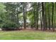 Charming brick home nestled among mature trees and a lush green lawn at 14236 Wyndfield Cir, Raleigh, NC 27615