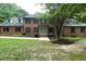 Inviting brick home with mature trees, manicured shrubs, and pathway leading to the front door at 14236 Wyndfield Cir, Raleigh, NC 27615