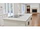 Open-concept kitchen with island cooktop overlooking living area and fireplace at 14236 Wyndfield Cir, Raleigh, NC 27615