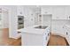 Modern kitchen featuring white cabinetry, stainless steel appliances, and a spacious island at 14236 Wyndfield Cir, Raleigh, NC 27615