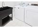 Functional laundry area with utility sink and appliances on tiled floor at 14236 Wyndfield Cir, Raleigh, NC 27615