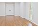Sunlit living room features hardwood floors, white walls, trim, and a large window at 14236 Wyndfield Cir, Raleigh, NC 27615