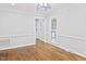 Bright living room with hardwood floors, white trim, and ample natural light from the large windows at 14236 Wyndfield Cir, Raleigh, NC 27615