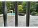 Views of the outdoor patio, complete with a pool and a pergola, visible through expansive windows at 14236 Wyndfield Cir, Raleigh, NC 27615