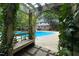 A gorgeous in-ground residential pool with a pergola, bench and climbing vines in a backyard setting at 14236 Wyndfield Cir, Raleigh, NC 27615
