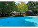 Lovely pool and landscaping on a property surrounded by mature trees at 14236 Wyndfield Cir, Raleigh, NC 27615
