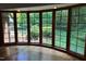 Sunroom with large windows offering views of the lush backyard landscaping and mature trees at 14236 Wyndfield Cir, Raleigh, NC 27615