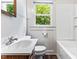 A functional bathroom featuring a tiled wall, toilet, vanity, and bathtub with essential fixtures at 1543 Wickham St, Burlington, NC 27215