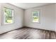 A bright bedroom featuring wood-look flooring and abundant natural light from two large windows at 1543 Wickham St, Burlington, NC 27215