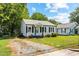 A charming single-story home is displayed with a gravel driveway and manicured lawn at 1543 Wickham St, Burlington, NC 27215