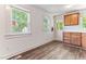 Kitchen featuring wood-look flooring, two windows, and wooden cabinets for a natural look at 1543 Wickham St, Burlington, NC 27215