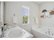 Bright bathroom showcasing double sinks, a soaking tub, and a large window with a view at 16 Daly Ct, Durham, NC 27705