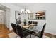 Elegant dining room with a glass-top table, black chairs, and a stylish chandelier at 16 Daly Ct, Durham, NC 27705