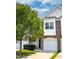 Inviting townhome showcases stone accents, a one car garage, and a well-manicured front yard at 16 Daly Ct, Durham, NC 27705