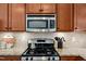 Close-up of a stainless steel kitchen range and microwave with granite countertops at 16 Daly Ct, Durham, NC 27705