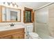 Well-lit bathroom with a wooden vanity, framed mirror, and tiled shower with glass door at 18 Frances St, Chapel Hill, NC 27517