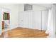 Bedroom featuring hardwood floors, white walls, and a connected bathroom and large closets at 18 Frances St, Chapel Hill, NC 27517