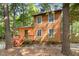 Two-story home surrounded by trees, featuring a front porch and ample natural light from numerous windows at 18 Frances St, Chapel Hill, NC 27517