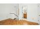 Open hallway with hardwood floors leads to a bathroom with wooden vanity at 18 Frances St, Chapel Hill, NC 27517