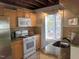 Well-lit kitchen with stainless steel appliances, wood cabinets, and stone tile floors at 18 Frances St, Chapel Hill, NC 27517