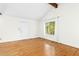 Spacious living room with hardwood floors, vaulted ceiling and a large window overlooking the yard at 18 Frances St, Chapel Hill, NC 27517