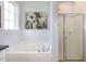Relaxing bathroom featuring a soaking tub and glass enclosed shower and natural light from the nearby window at 20 Ingate Way, Louisburg, NC 27549