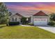Charming one-story home with a well-manicured lawn, two car garage, and beautiful landscaping in a peaceful neighborhood at 20 Ingate Way, Louisburg, NC 27549