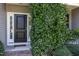 Close-up of a black front door framed by white sidelights and lush greenery at 20 Ingate Way, Louisburg, NC 27549