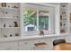 Bright eat-in kitchen features white cabinets, shelving, and a window with backyard view at 2003 Ryerson Dr, Garner, NC 27529