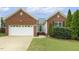 Charming brick home featuring an attached garage, well-maintained lawn, and manicured landscaping at 2012 Summer Shire Way, Raleigh, NC 27604