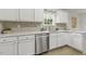 Contemporary kitchen with stainless dishwasher, white cabinets, and tiled backsplash at 2012 Summer Shire Way, Raleigh, NC 27604