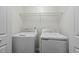 A laundry room features a white washer and dryer beneath a wire rack at 2012 Summer Shire Way, Raleigh, NC 27604