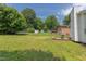 Spacious backyard with a green lawn, mature trees, and a storage shed, all within a secure fenced perimeter at 2014 Athens Ave, Durham, NC 27707