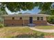 Charming single-story home with a brick facade, blue front door, manicured lawn, and mature trees at 2014 Athens Ave, Durham, NC 27707