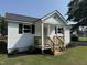 Beautiful exterior showcasing a white home with black shutters and a wooden porch at 203 Hope St, Erwin, NC 28339