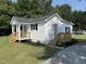 Exterior view showcasing a white home with a wooden porch and manicured landscaping at 203 Hope St, Erwin, NC 28339