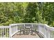 Iron table and chairs with nature views from this wood back deck at 205 Aurora Rd, Hillsborough, NC 27278