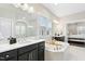 Bright primary bathroom featuring a soaking tub, double vanity, and glass enclosed shower at 205 Aurora Rd, Hillsborough, NC 27278