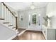 Bright foyer featuring hardwood floors, a staircase, chandelier lighting, and a front door with sidelights at 205 Aurora Rd, Hillsborough, NC 27278