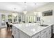 Open kitchen featuring a large island, pendant lighting, stainless steel sink, and views of the dining area at 205 Aurora Rd, Hillsborough, NC 27278