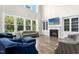 Bright living room features a fireplace, large windows, hardwood floors, and ample seating for guests at 205 Aurora Rd, Hillsborough, NC 27278
