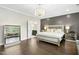 Main bedroom with a chandelier, accent wall, and ensuite bathroom at 205 Aurora Rd, Hillsborough, NC 27278