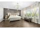 Main bedroom featuring a decorative light fixture, accent wall, and natural light at 205 Aurora Rd, Hillsborough, NC 27278