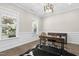Bright home office with hardwood floors, two large windows, and a modern desk with a leather chair at 205 Aurora Rd, Hillsborough, NC 27278