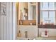 Bathroom featuring a small sink, wooden framed mirror, and a window for plenty of natural light at 216 Northwood Cir, Durham, NC 27701