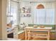 Cozy breakfast nook with wood table, cushioned benches, open shelves, and natural light streaming through sheer curtains at 216 Northwood Cir, Durham, NC 27701