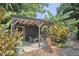 Outdoor workout space on the covered patio with a wooden bench and landscaping at 216 Northwood Cir, Durham, NC 27701